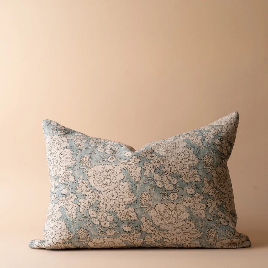 Floral patterned pillow on a beige and blue background