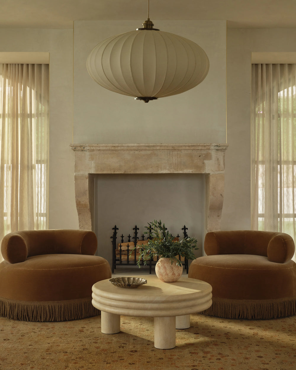 Modern living room with two brown armchairs, a stone coffee table, and a decorative lamp.