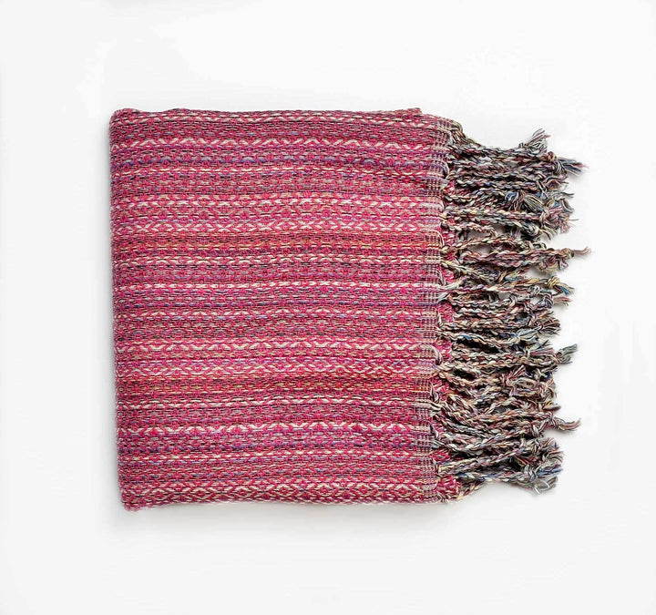 Woven pink and purple blanket/turkish towel with fringes on a white background